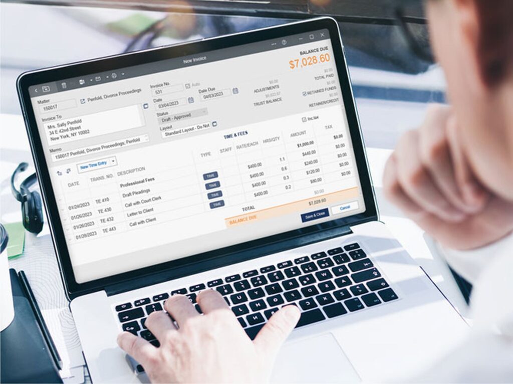 Person using invoicing software on a laptop